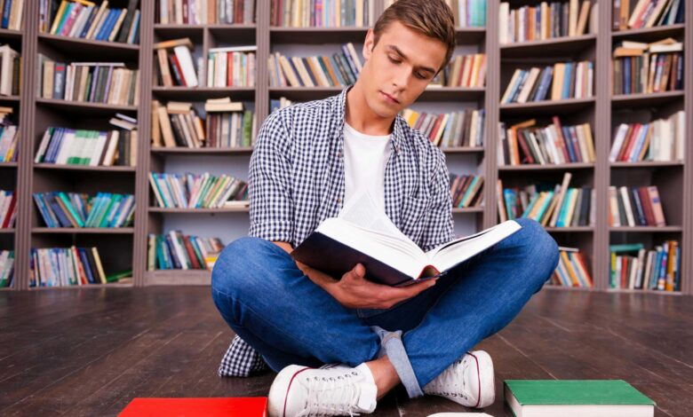 3 stories and lessons of our Islamic heritage 1 doing his research in library concentrated young man reading book while sitting against bookshelf free photo optimized scaled
